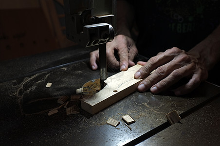 木匠生成器使用电动拼图和木头 切割一块木头的木工男人金属工作工程木制品芯片建造机器维修职业图片