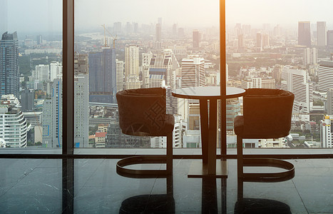 两张现代椅子和圆玻璃桌 放在高塔办公室工作大堂地面房间金属装饰奢华窗户商业建筑图片