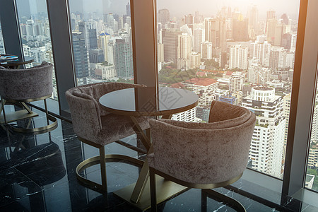 两张现代椅子和圆玻璃桌 放在高塔办公室家具大堂窗户桌子奢华玻璃地面房间装饰金属图片