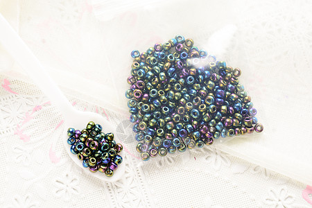 白色织物表面上的彩色珠子 各种形状和 c石头玻璃工艺蓝色礼物手工女性配饰产品艺术图片
