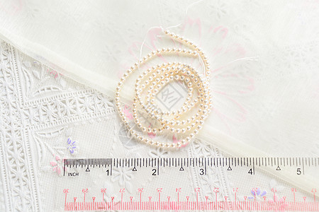 白色布料背景上的珍珠项链 近距离拍摄宝藏宝石风格奢华新娘妈妈们反射珠子石头配饰图片