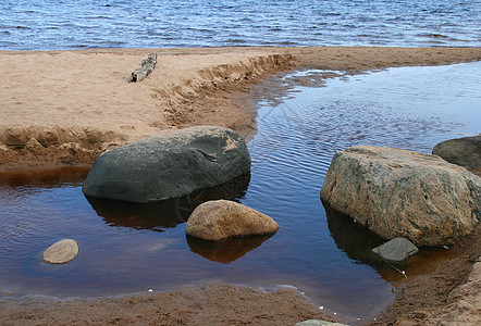 蓝湖海岸上的大块石头 有沙滩图片