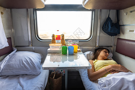国内保留座位火车车 女孩睡在下架的货架上图片