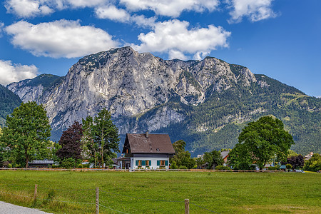 奥地利Altaussee附近的阿尔卑斯山房子岩石天空绿色牧场场地树木乡村风景旅行图片