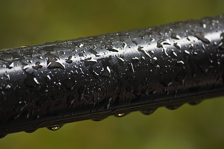 湿黑手栏覆盖在雨水滴中图片
