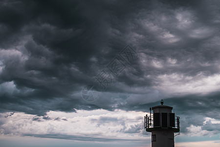 在暴风云前的灯塔石头风暴力量海岸日落阳光建筑海洋支撑天空图片