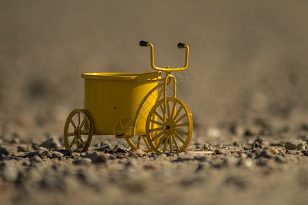 户外黄色玩具自行车阴影运输座位闲暇娱乐车辆踏板碎石乐趣轮子图片