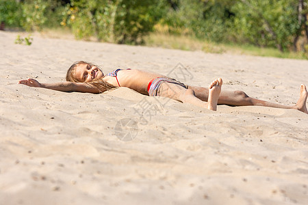 独自在河沙河海滩上做日光浴的少女图片