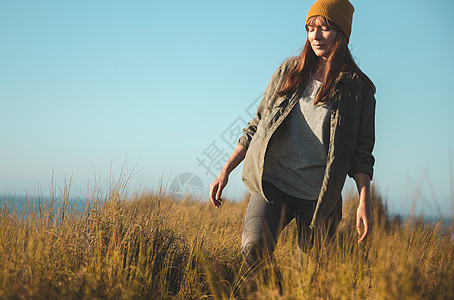 黄帽妇女旅行假期享受远足蓝色沙丘游客海洋海岸女孩图片