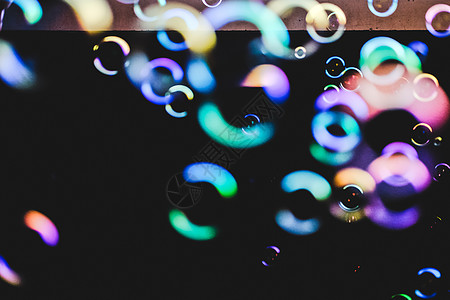 深色背景上的七彩泡泡液体肥皂反射桌面气球圆圈黑暗乐趣孩子场地图片