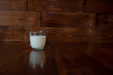 在玻璃牛奶罐中的牛奶木头杯子健康用具水壶奶牛饮料液体茶点营养图片