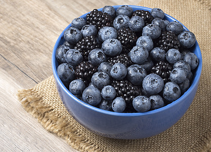 满碗新鲜黑莓和蓝莓 在木头背上甜点桌子采摘营养美食浆果植物蓝色食物森林浆果图片