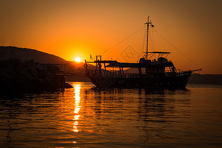 渔民准备在希腊清晨的海中出海钓鱼 太阳反射得很漂亮 笑声阳光橙子海岸旅行海洋天空日落热带蓝色背光图片