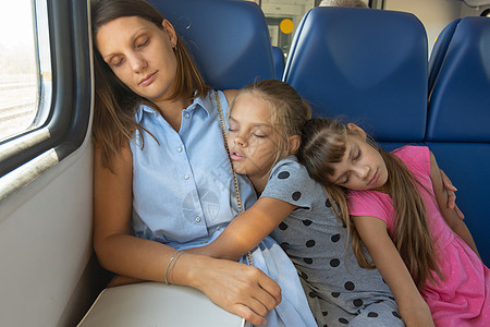母亲和两个女儿在一辆电动火车车上睡着图片