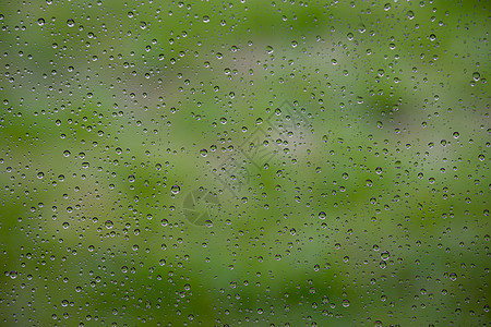 窗玻璃上的水滴天气雨滴绿色液体窗户反射背景图片