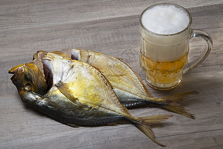 啤酒和木桌上的干鱼食物盐渍酒吧泡沫状熏制美食海鲜木头小吃玻璃图片