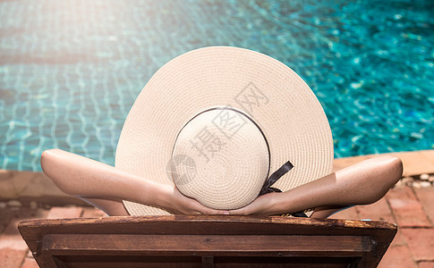 戴大帽子的亚裔年轻女子 在游泳池里晒日光浴娱乐水池椅子温泉热带甲板闲暇生活休息室酒店图片