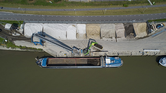 在小泊位上装满沙子和瓦砾的驳船商品水路发动机海浪船运导航货运拖船支撑蓝色图片