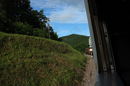 在泰国 从火车窗口观看乡村与天空运动 天气晴朗温暖速度旅游背包农村运输椅子乘客天空玻璃日落图片