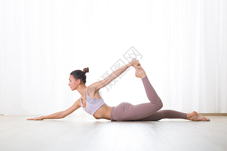 在工作室练习瑜伽的华丽活跃运动型年轻女子的画像 美丽的女孩练习半弓瑜伽姿势 健康积极的生活方式 在室内健身房锻炼图片