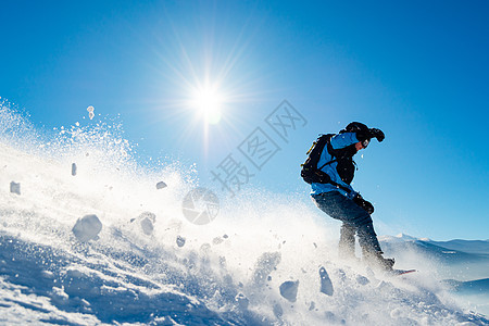 滑雪运动员在太阳尼日登上山峰的雪板 滑雪和冬季运动天空行动风镜速度乐趣季节滑雪板娱乐下坡晴天图片