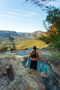 冒险女性在山边峡谷尽头享受跳水池的冒险图片