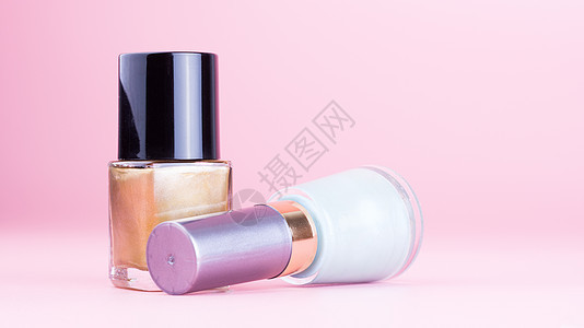 两瓶指甲油金子粉色美甲搪瓷工作室液体瓶子指甲女性化化妆品背景图片