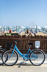 在海滩上租车 在街上买蓝色自行车锻炼民众假期城市运动交通车轮车辆街道旅游背景图片