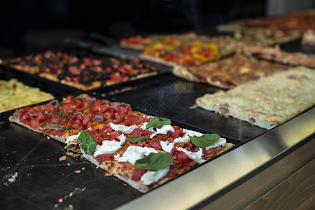 意大利街比萨饼店 展示中的披萨面包陈列柜蔬菜火腿窗户街道圆圈营养面团铺面图片