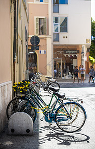 骑在意大利街自行车站上的自行车生态游客街道太阳框架运动场景车轮旅行潮人图片
