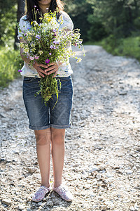 女人拿着花束草地女性花朵场地植物篮子女孩采摘园艺植物群图片