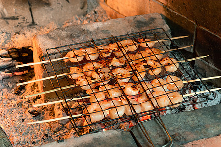 在炉子上烧烤火煤的竹叉上的虾派对动物美食木炭食物海鲜贝类油炸甲壳火炉图片