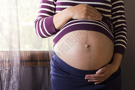 孕妇向窗边的窗口窗户女士成人婴儿肚子房间女孩母亲房子腹部图片