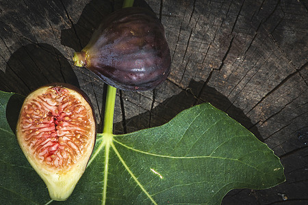 木柴上的长形和叶叶子木头叶子水果紫色热带食物绿色无花果饮食红色图片