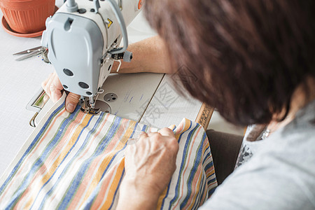妇女缝制缝纫机裁缝女裁缝工作白色工艺衣服纺织品剪裁工作室制造业图片