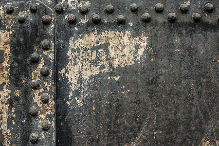 有铆钉的金属墙壁黑色盘子盔甲材料框架螺栓灰色工业床单图片