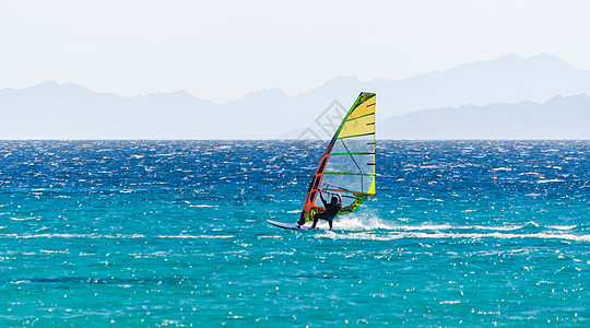 一次在红海冲浪者骑马 在岩石背景下旅行运动员石头海岸风帆游泳支撑地平线冲浪假期图片