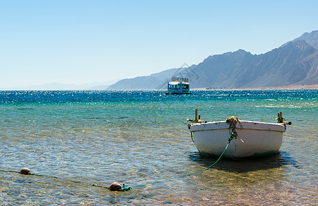 海洋中旧的木头渔船在H和H的背景之下运输旅游旅行蓝色海岸地平线山脉浮标支撑假期图片