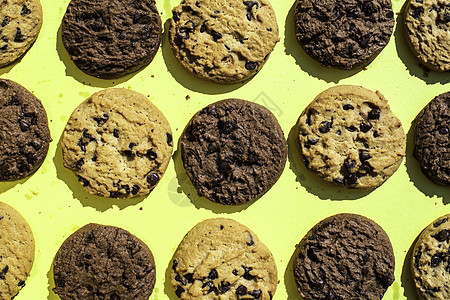 黄色背景的饼干巧克力棕色传统白色面包屑餐巾宏观早餐蛋糕芯片图片