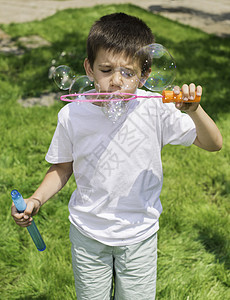 儿童制造泡沫肥皂乐趣幸福闲暇公园太阳气泡孩子绿色童年图片