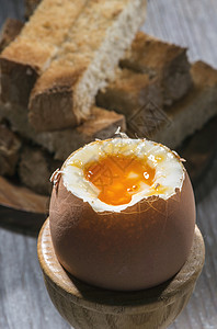 桌上的软煮鸡蛋面包黄色棕色杯子食物早餐桌子饮食勺子蛋壳图片