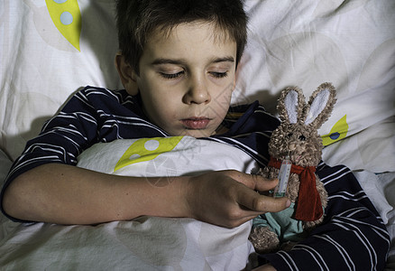 与泰迪熊同床睡的生病儿童玩具病人孩子们男生药品发烧流感房间医院温度计图片