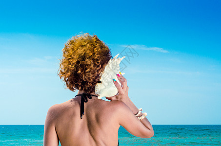 红头发的年轻女子 大海壳和多彩男子图片