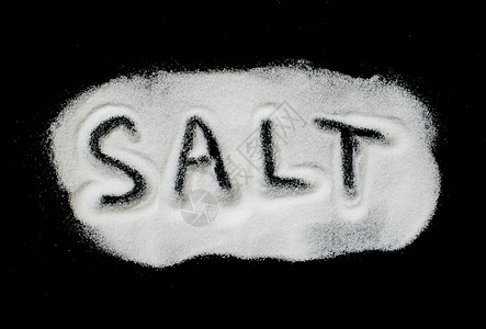 黑色背景上的单词盐调味品味道食欲白色晶体盐瓶水晶玻璃洗澡摇床图片
