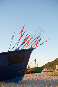 日出时在海滩上钓鱼船海洋运输旅行漂浮木头蓝色海岸文化日落渔夫图片