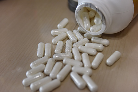 桌子上白塑料瓶中的药片图片
