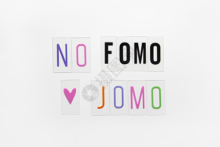 白色背景透明塑料上的缩写词 FOMO JOMO FOMO 意味着害怕错过 JOMO  错过的快乐 反对 选择 社会问题 数字排毒图片