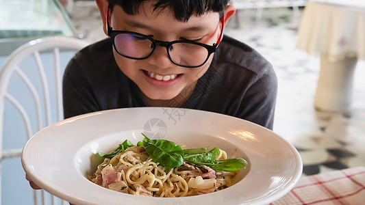 男孩喜欢吃意粉卡波纳拉食谱  人们喜欢意大利著名菜肴的概念烹饪盘子食物猪肉胡椒火腿午餐营养桌子奶油图片