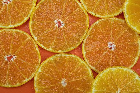 鲜切多汁的橙色水果镶嵌在橙色背景上  热带橙色水果质地 供背景使用橙叶橙片工作室食物橘子橙子果汁叶子图片