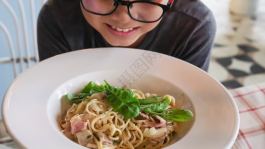 男孩喜欢吃意粉卡波纳拉食谱  人们喜欢意大利著名菜肴的概念面条烹饪厨房猪肉食谱午餐桌子火腿盘子美食图片